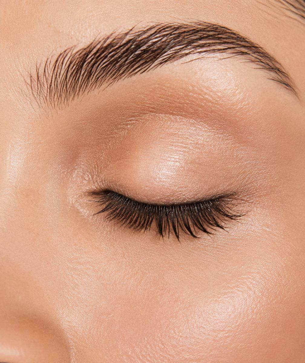 Close-up beauty photograph of an adult's closed eye showing lifted lashes